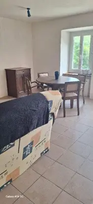 a room with a table and a bed and a table and chairs at Au Grand Mûrier in Roquefère