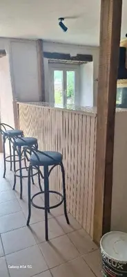 a row of bar stools in a room with a window at Au Grand Mûrier in Roquefère