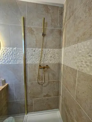 a shower with a glass door in a bathroom at Tout confort ! Balnéo, Sauna, Cinéma, Climatisation, Parking, WiFi in Carcassonne