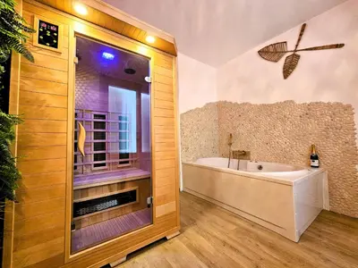a bathroom with a tub and a sink and a bath tub at Tout confort ! Balnéo, Sauna, Cinéma, Climatisation, Parking, WiFi in Carcassonne