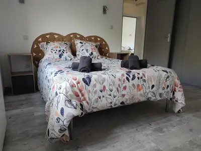 a bedroom with a bed with a floral bedspread at Au coeur de l'occitanie in Cuq