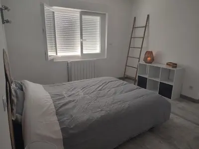 a bedroom with a bed and a ladder and a window at Au coeur de l'occitanie in Cuq
