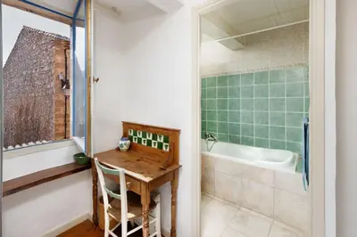 a bathroom with a wooden table and a bath tub at Villa en campagne avec cour intérieure in Arques