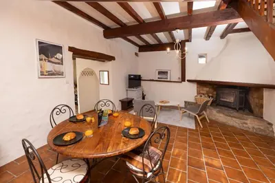a dining room with a table and chairs and a fireplace at Villa en campagne avec cour intérieure in Arques