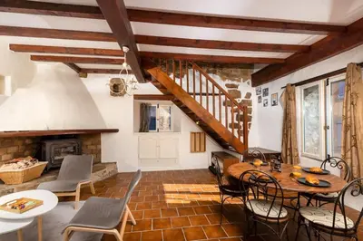 a living room with a table and chairs and a staircase at Villa en campagne avec cour intérieure in Arques