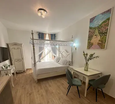 a bedroom with a bed and a table with chairs at Studio à Baldaquin du Cloitre in Narbonne