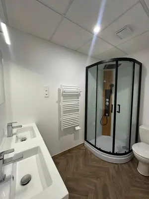 a bathroom with a glass shower and a toilet at Studio à Baldaquin du Cloitre in Narbonne