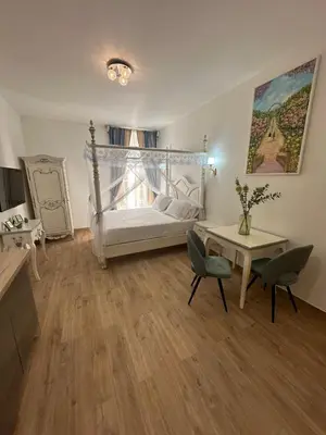a bedroom with a bed and a table and chairs at Studio à Baldaquin du Cloitre in Narbonne