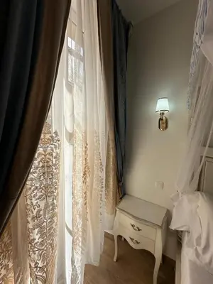a bedroom with a window with a table and a lamp at Studio à Baldaquin du Cloitre in Narbonne