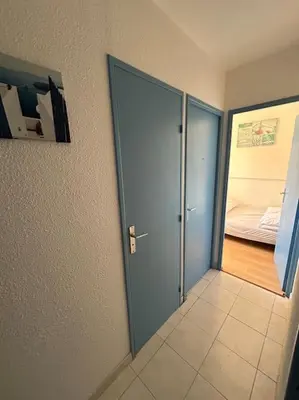 a room with an open door and a bedroom at L'Albatros in Gruissan