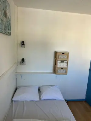 a room with a bed with a phone on the wall at L'Albatros in Gruissan