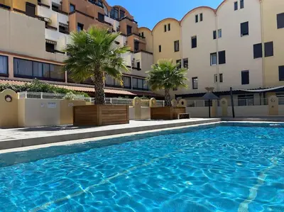 a large swimming pool in front of some buildings at L'Albatros in Gruissan