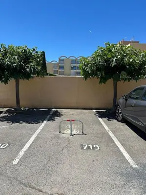 a car parked in a parking lot next to a wall at L'Albatros in Gruissan