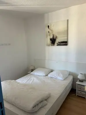 a bed in a bedroom with a picture on the wall at L'Albatros in Gruissan