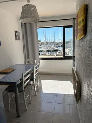 a dining room with a table and a view of a marina at L'Albatros in Gruissan
