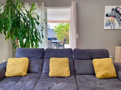 a blue couch with two yellow pillows on it at Villa des Perdrix - Piscine et Clim - 120m2 in Lavalette