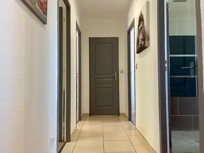 a hallway with a brown door and a tile floor at Villa des Perdrix - Piscine et Clim - 120m2 in Lavalette