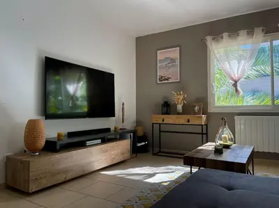 a living room with a large flat screen tv at Villa des Perdrix - Piscine et Clim - 120m2 in Lavalette