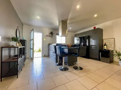 a kitchen with a table and chairs in a room at Villa des Perdrix - Piscine et Clim - 120m2 in Lavalette