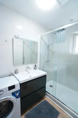 a bathroom with a sink and a washing machine at Appartement du Forum,La gare, 50 m2 , Climatisation, Garage, Cour in Narbonne