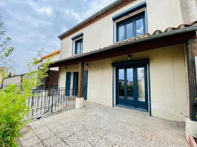 a house with blue doors and a balcony at Maison Rosy in Carcassonne