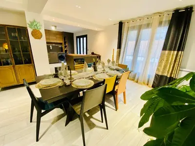 a dining room with a black table and chairs at Maison Rosy in Carcassonne