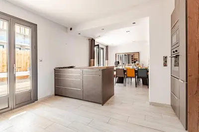a kitchen with a counter and a dining room at Maison Rosy in Carcassonne