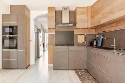 a kitchen with stainless steel appliances and wooden cabinets at Maison Rosy in Carcassonne