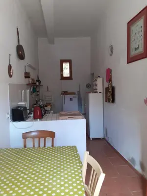 a kitchen with a table and chairs and a refrigerator at Location maison de campagne 5 personnes in Quarante