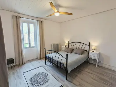 a bedroom with two beds and a ceiling fan at à 5mn de la réserve Africaine, charmante maison de village avec patio in Sigean