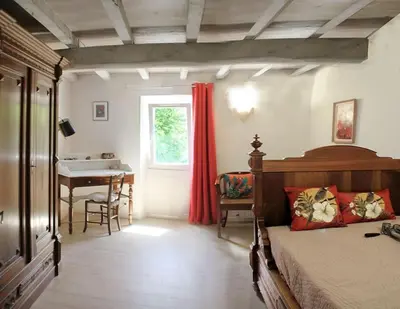 a bedroom with a bed and a table and a window at La Maison de Berthe - Havre de paix dans la campagne - Entièrement rénovée et équipéé in Montmaur
