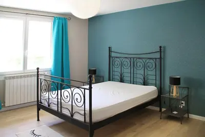 a bedroom with a bed and a blue wall at La Maison de Berthe - Havre de paix dans la campagne - Entièrement rénovée et équipéé in Montmaur