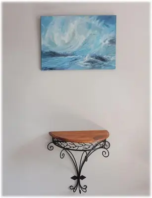 a table in front of a painting on a wall at La Maison de Berthe - Havre de paix dans la campagne - Entièrement rénovée et équipéé in Montmaur