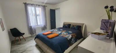 a bedroom with a bed with orange pillows on it at Villa Papillons Narbonne Centre in Narbonne