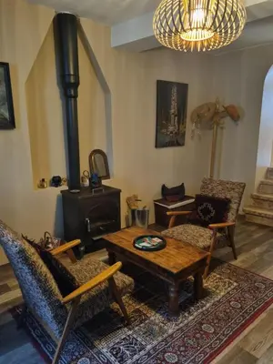 a living room with a table and a wood stove at Maison de charme in Caunes-Minervois