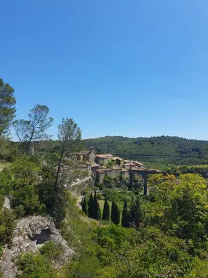 a village on the side of a hill with trees at Maison de charme in Caunes-Minervois