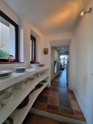 a kitchen with white shelves with dishes on them at Maison de charme in Caunes-Minervois