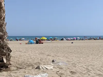 a group of people on a beach with umbrellas at T2 Climatisé 4 pers. avec Parking, Front de mer, Port-la-Nouvelle - FR-1-797-10 in Port-la-Nouvelle