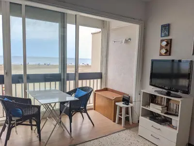 a living room with a table and a television and the beach at T2 Climatisé 4 pers. avec Parking, Front de mer, Port-la-Nouvelle - FR-1-797-10 in Port-la-Nouvelle