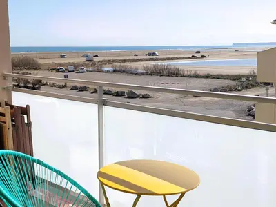 a balcony with a yellow chair and a view of the beach at Bel appartement T2 climatisé avec piscine et parking à 250m de la plage - FR-1-797-9 in Port-la-Nouvelle
