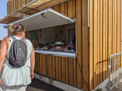 a woman with a backpack standing outside of a building at Bel appartement T2 climatisé avec piscine et parking à 250m de la plage - FR-1-797-9 in Port-la-Nouvelle