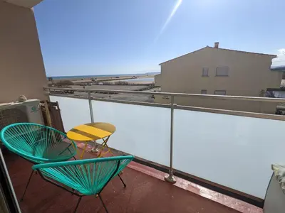 a balcony with two chairs and a table on it at Bel appartement T2 climatisé avec piscine et parking à 250m de la plage - FR-1-797-9 in Port-la-Nouvelle