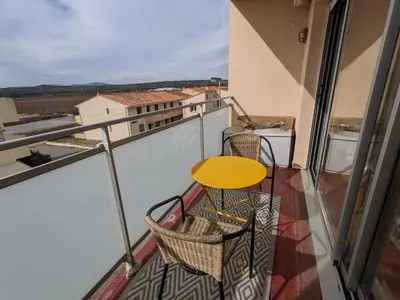 a balcony with a yellow table and chairs and a table at Bel appartement T2 climatisé avec piscine et parking à 250m de la plage - FR-1-797-9 in Port-la-Nouvelle