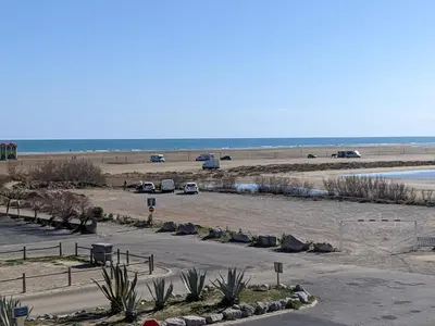 a parking lot with cars parked on the beach at Bel appartement T2 climatisé avec piscine et parking à 250m de la plage - FR-1-797-9 in Port-la-Nouvelle