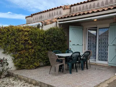 a table and chairs on a patio outside of a house at Charmante Villa T3 Climatisée Proche Plage - Confort et Calme pour 6 Pers. - FR-1-797-21 in Port-la-Nouvelle