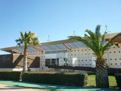 a building with palm trees in front of it at T2 Climatise en RDC Face Mer 5 Pers PKG - FR-1-797-7 in Port-la-Nouvelle