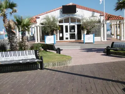 three park benches sitting in front of a building at T2 Climatise en RDC Face Mer 5 Pers PKG - FR-1-797-7 in Port-la-Nouvelle