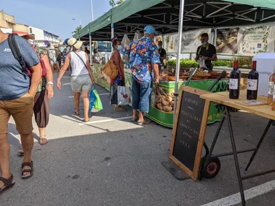 a group of people walking around a farmers market at T2 climatisé en front de mer avec parking - FR-1-797-13 in Port-la-Nouvelle