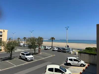 a parking lot with cars parked next to the beach at T2 climatisé en front de mer avec parking - FR-1-797-13 in Port-la-Nouvelle