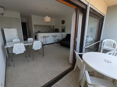 a kitchen and a living room with a table and chairs at T2 climatisé en front de mer avec parking - FR-1-797-13 in Port-la-Nouvelle